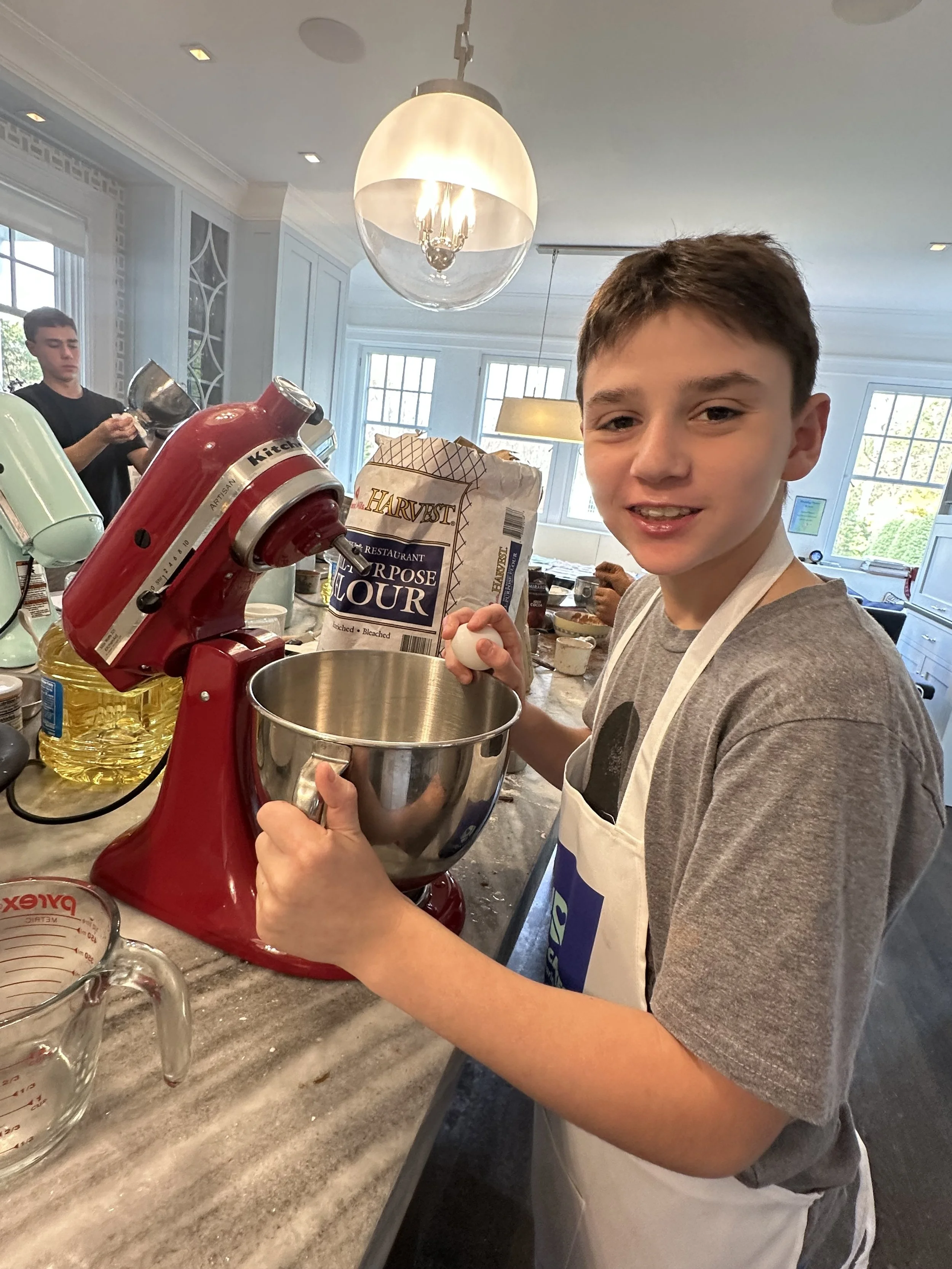 Young baker preparing ingredients beside a red mixer