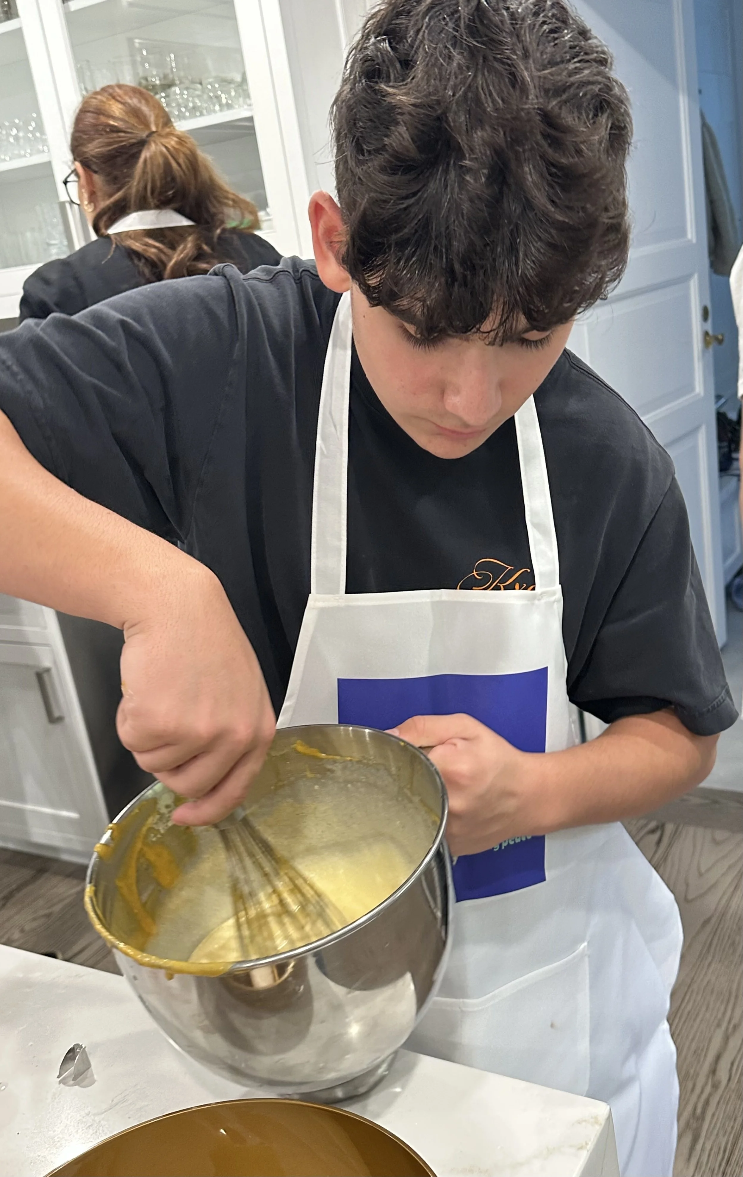Young baker whisking cake batter