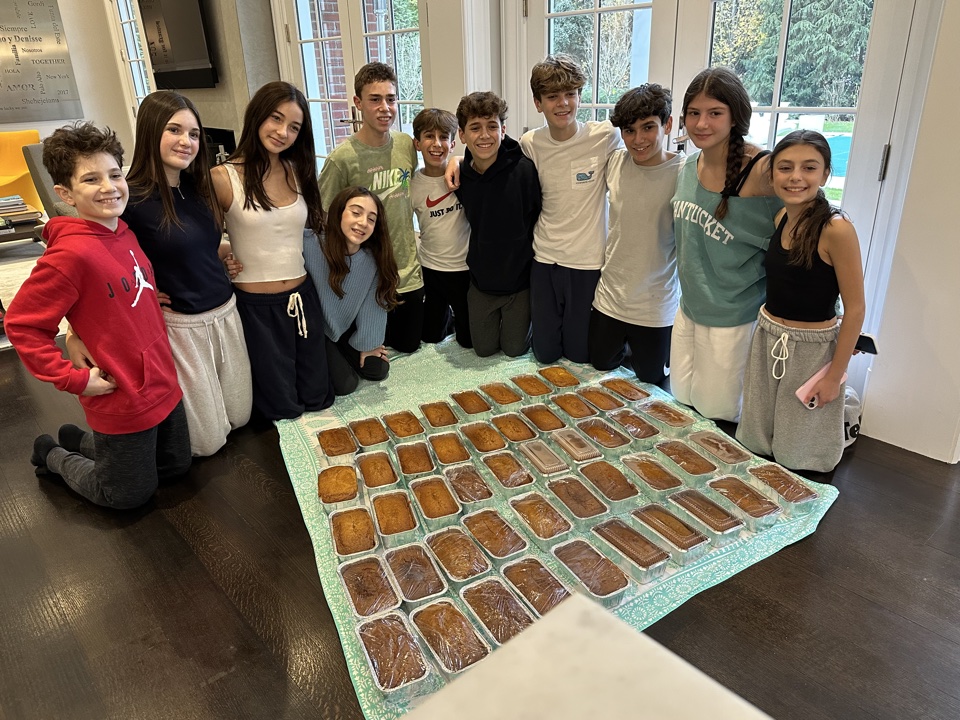 PeaceofCakes team gathered around rows of freshly baked loaves