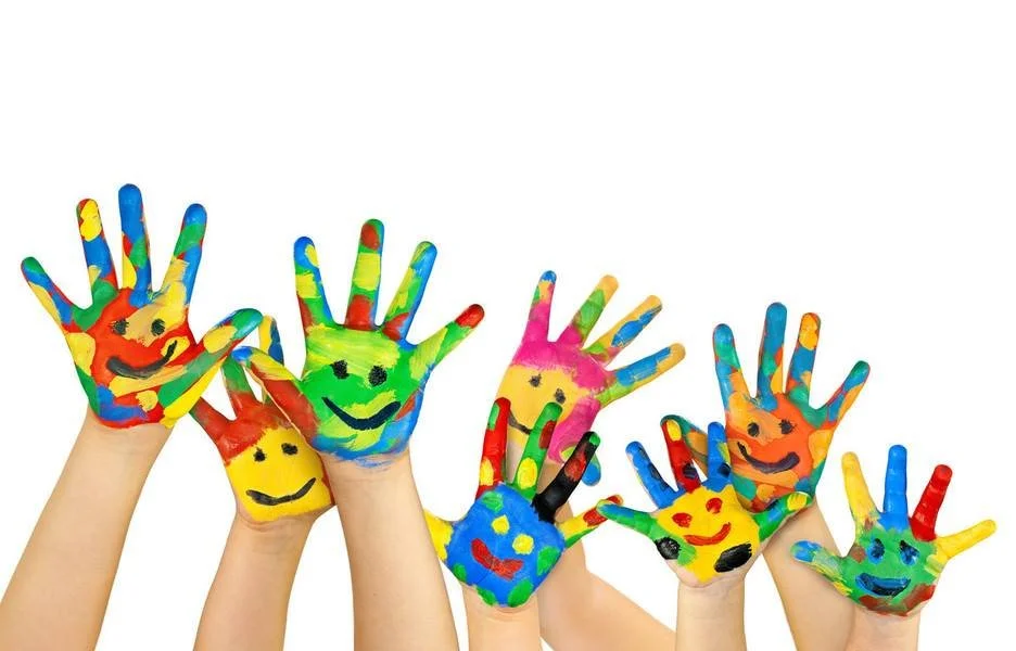 Children’s hands brightly painted with colorful smiling faces